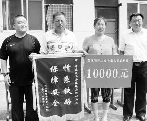 北京铁路局丰台工务段赠予卢伟夫妇锦旗与奖金。