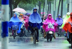 昨天下午，南京飘起雨，骑车的市民穿起雨披