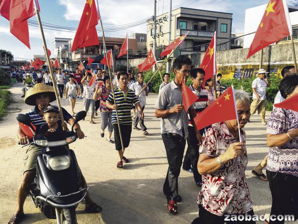 乌坎村民昨天手持中国国旗在村内游行，要求当局释放村党总支书记、村委会主任林祖恋。（路透社）