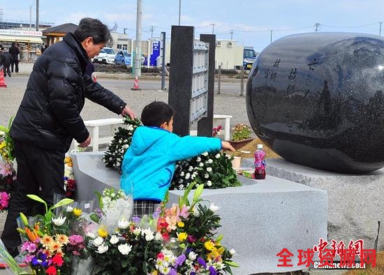 资料图：当年人员损失最为惨重的宫城县内各地，民众在当地建起的慰灵碑前献花祭悼。王健 摄