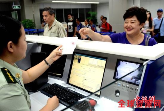 资料图：一名搭乘MF880航班从台北桃园飞抵福州长乐国际机场的台胞在福州机场边检站办理办理入境手续时免签注，经过人像对照和核查证件有效无异常后顺利通关。中新社发 刘可耕 摄