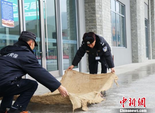 贵铁警方在进站通道铺设布垫，防止乘客滑到。 贵铁警方供图 张伟 摄