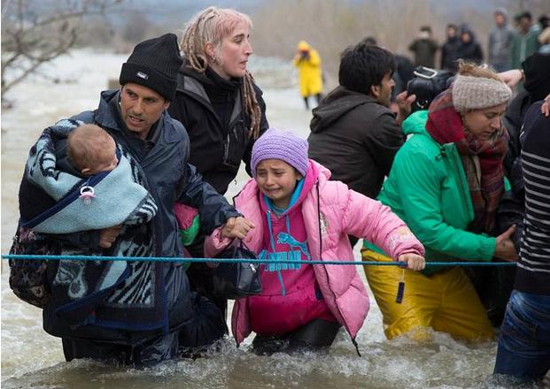 全球:千难民组人链渡河 已有3人淹死