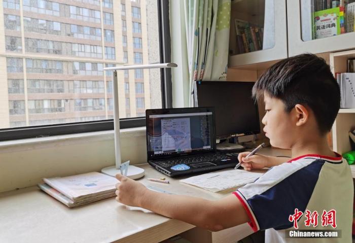 资料图：一小学生在家中通过平板电脑收看直播上数学课。 中新社记者 翟羽佳 摄